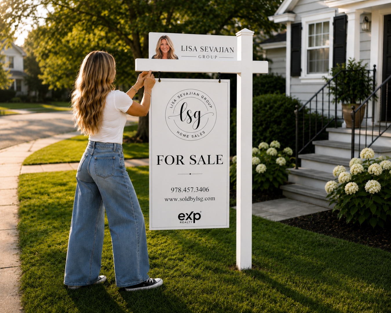 Lisa Sevajian hanging a sold sign
